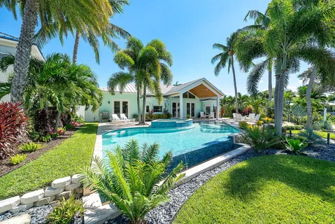 a front view of a house with swimming pool garden and patio