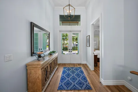 a hallway with a chandelier and wooden floor