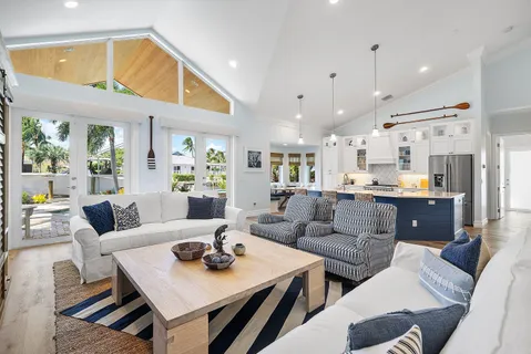a living room with furniture kitchen view and a large window