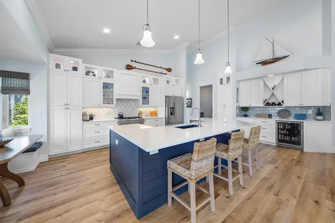 an open kitchen with wooden floor and stainless steel appliances