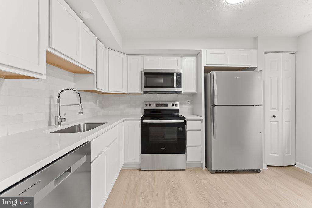 14743 Winding Loop Woodbridge, VA 22191 - Photo 11 of 36 a kitchen with a refrigerator stove and a sink