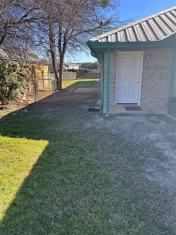 a view of an house with backyard space and tree