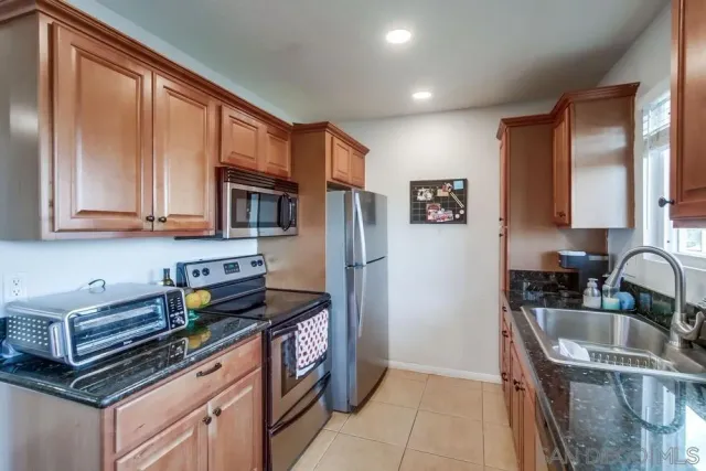 a kitchen with stainless steel appliances granite countertop a refrigerator stove and sink