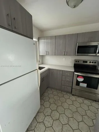 a kitchen with stainless steel appliances a stove a sink a microwave a refrigerator and cabinets