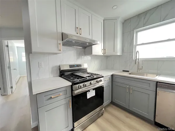 a kitchen with stainless steel appliances white cabinets and a stove a sink