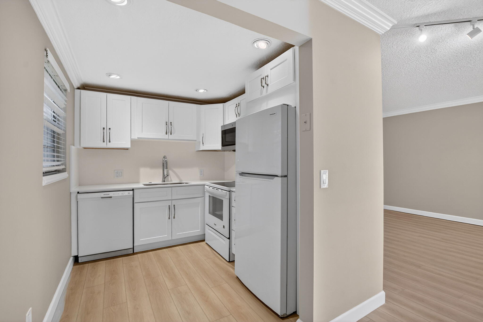 277 Brighton Drive, Unit G Boca Raton, FL 33434 - Photo 12 of 44 a kitchen with white cabinets and white appliances