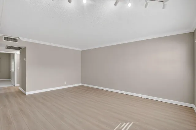 a view of an empty room with wooden floor