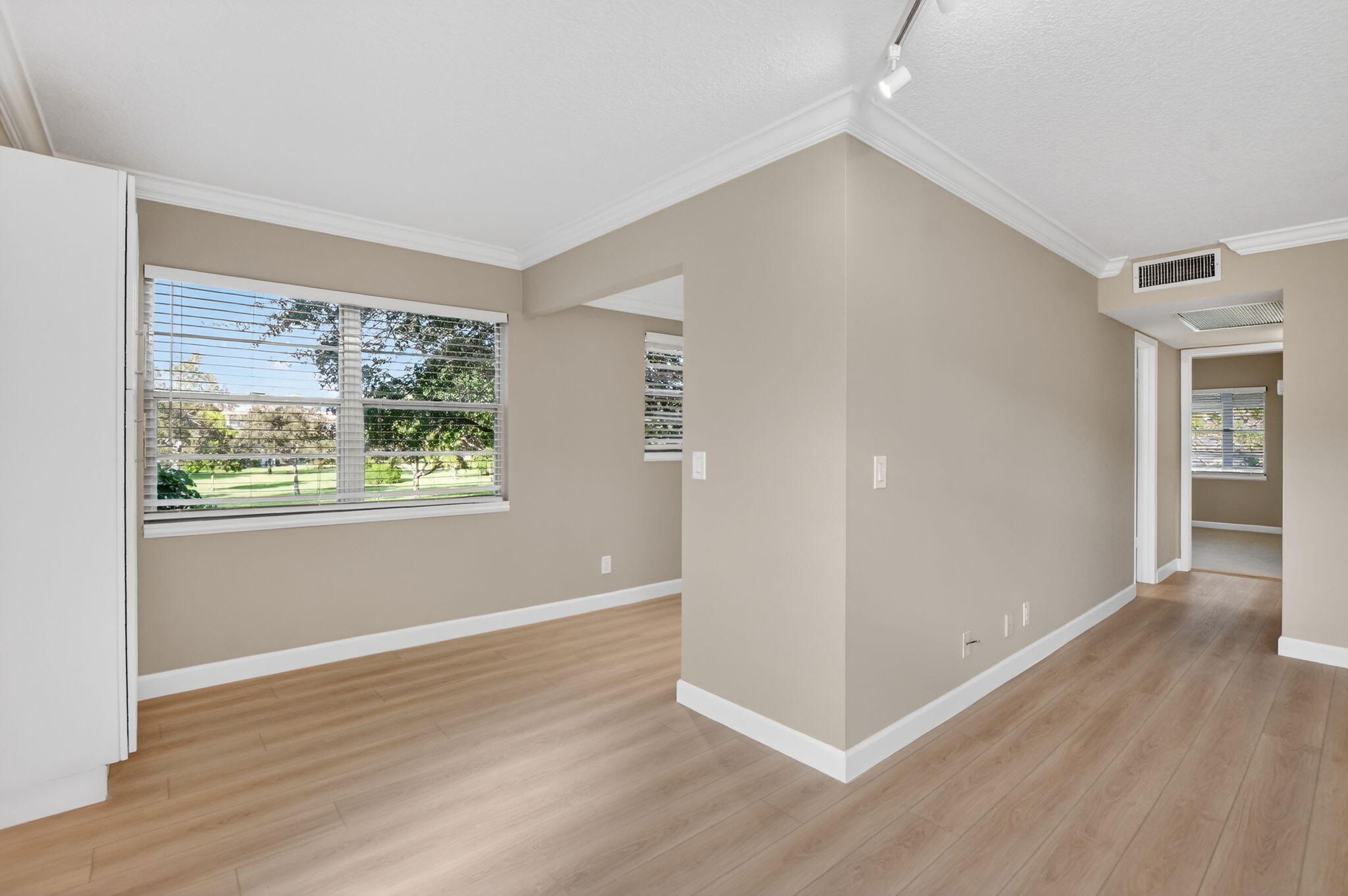 277 Brighton Drive, Unit G Boca Raton, FL 33434 - Photo 10 of 44 an empty room with wooden floor and windows