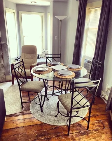 a view of a dining room with furniture window and wooden floor