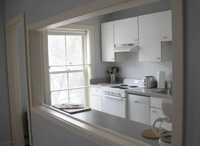 a kitchen with stainless steel appliances white cabinets and a window