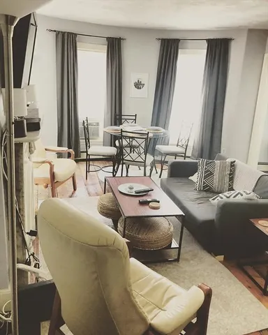 a living room with furniture and a large mirror