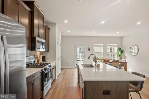 a kitchen with stainless steel appliances granite countertop a sink a stove and a refrigerator