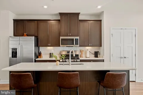 a kitchen with stainless steel appliances a sink and a refrigerator
