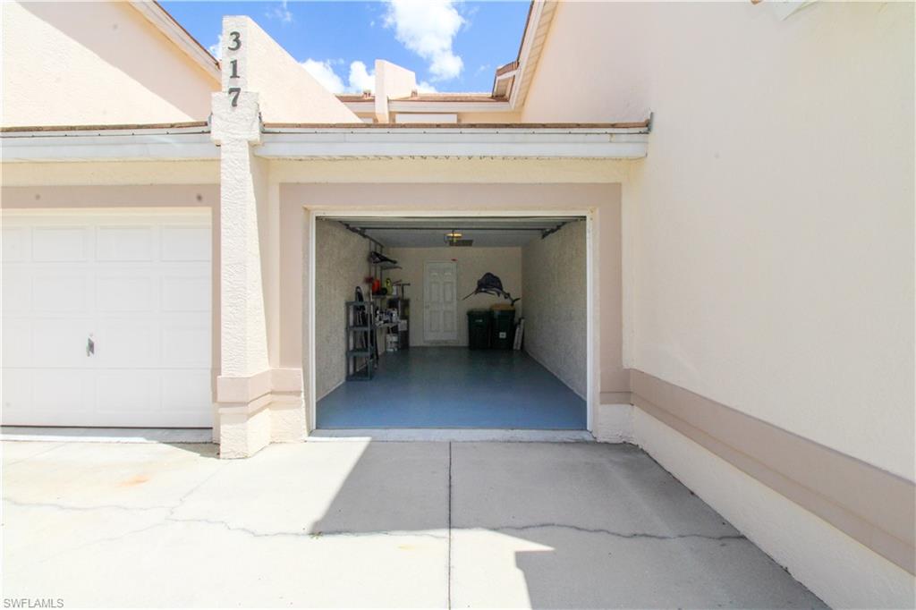 317 Sunrise Cay, Unit 103 Naples, FL 34114 - Photo 8 of 50 a view of a hallway with wooden floor and staircase