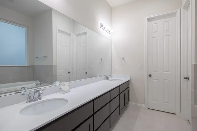 a spacious bathroom with a double vanity sink and a mirror