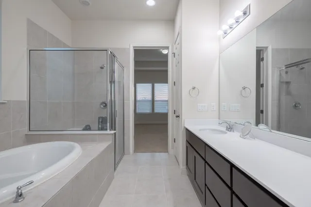 a bathroom with a tub sink shower and two mirror