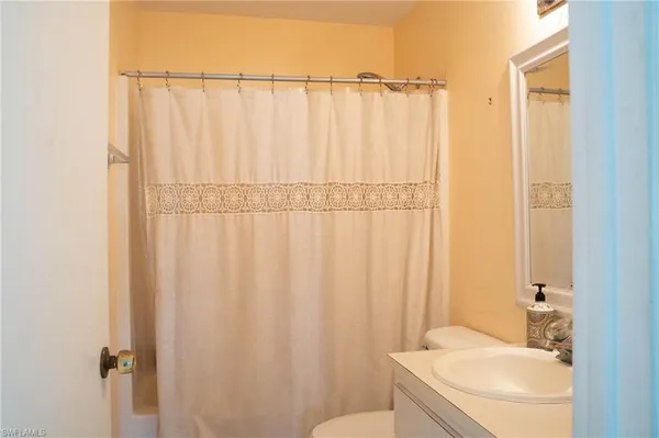 a bathroom with a toilet and a shower curtain