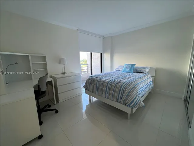 a bedroom with a bed chair and windows