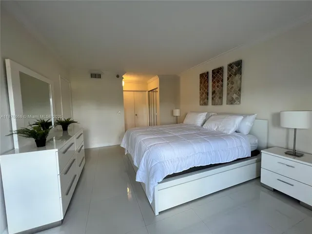 a spacious bedroom with a bed a couch and dresser