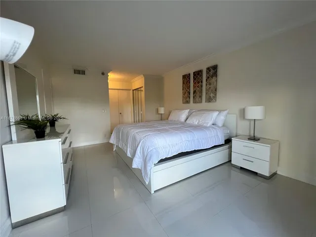 a bedroom with a bed and a potted plant