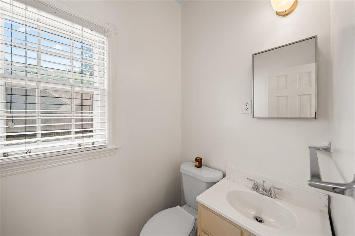 1273 Brookfield Road Memphis, TN 38119 - Photo 20 of 40 1/2 bathroom featuring a window with blinds, a built-in vanity with a white sink, a wall-mounted medicine cabinet, and a toilet