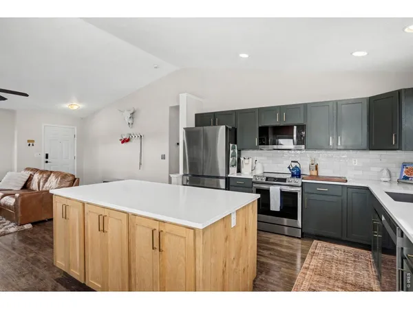 a kitchen with stainless steel appliances granite countertop a refrigerator stove microwave and sink