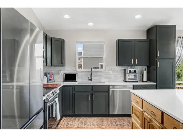 a kitchen with kitchen island a sink stove and refrigerator