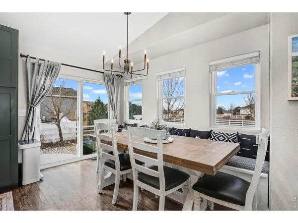 a kitchen with stainless steel appliances kitchen island granite countertop a table chairs and a refrigerator