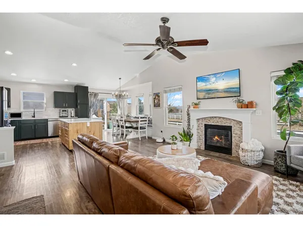 a living room with furniture kitchen view and a wooden floor