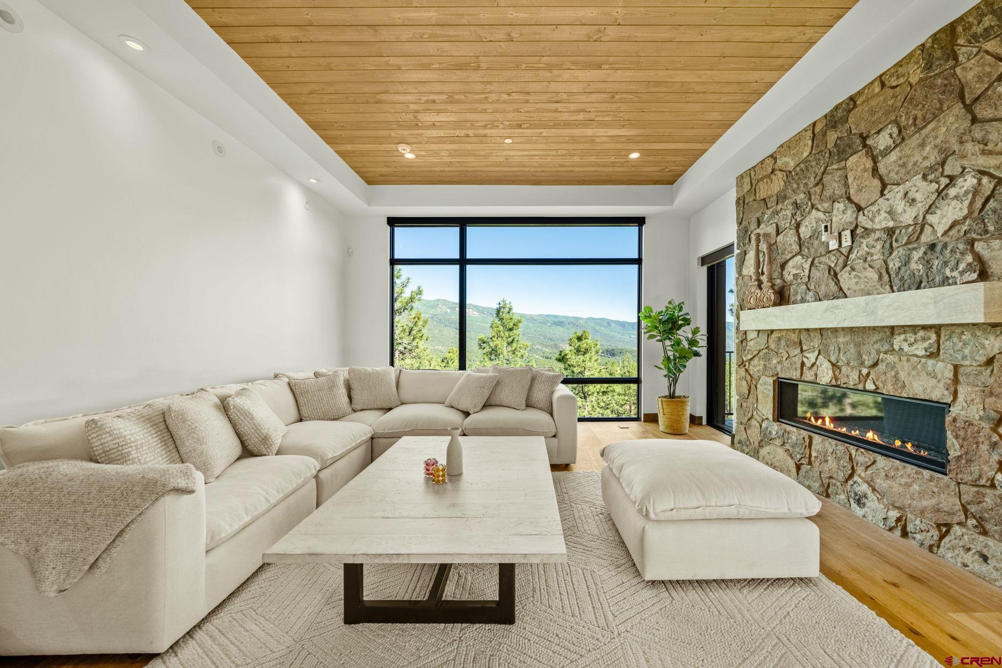 136 Outlaw Drive, Unit 3B Durango, CO 81301 - Photo 11 of 45 a living room with furniture a flat screen tv and a floor to ceiling window