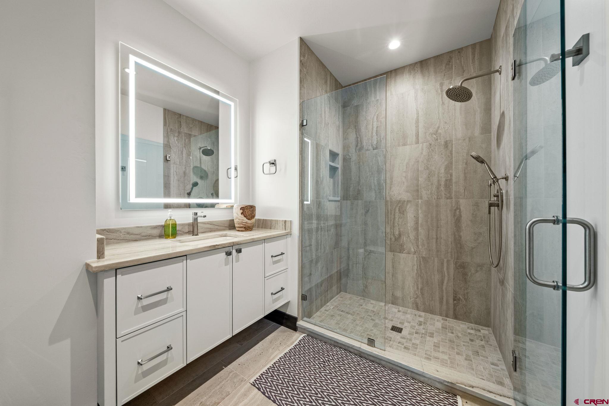 136 Outlaw Drive, Unit 3B Durango, CO 81301 - Photo 39 of 45 a bathroom with a shower a sink and a mirror