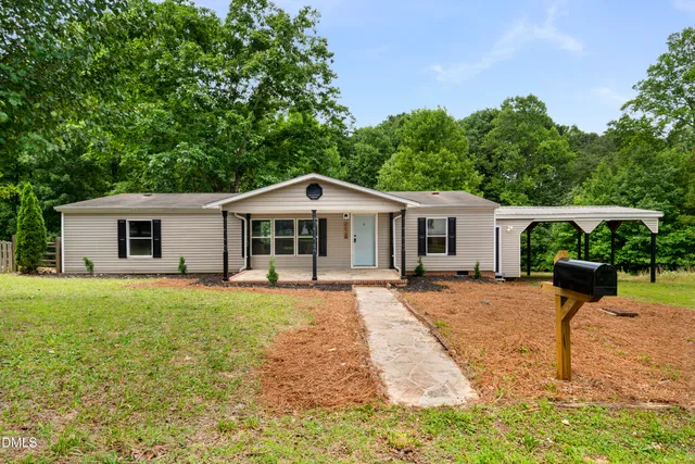 a front view of a house with a yard and trees