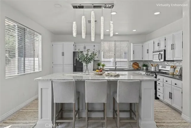 a kitchen with appliances cabinets and chair