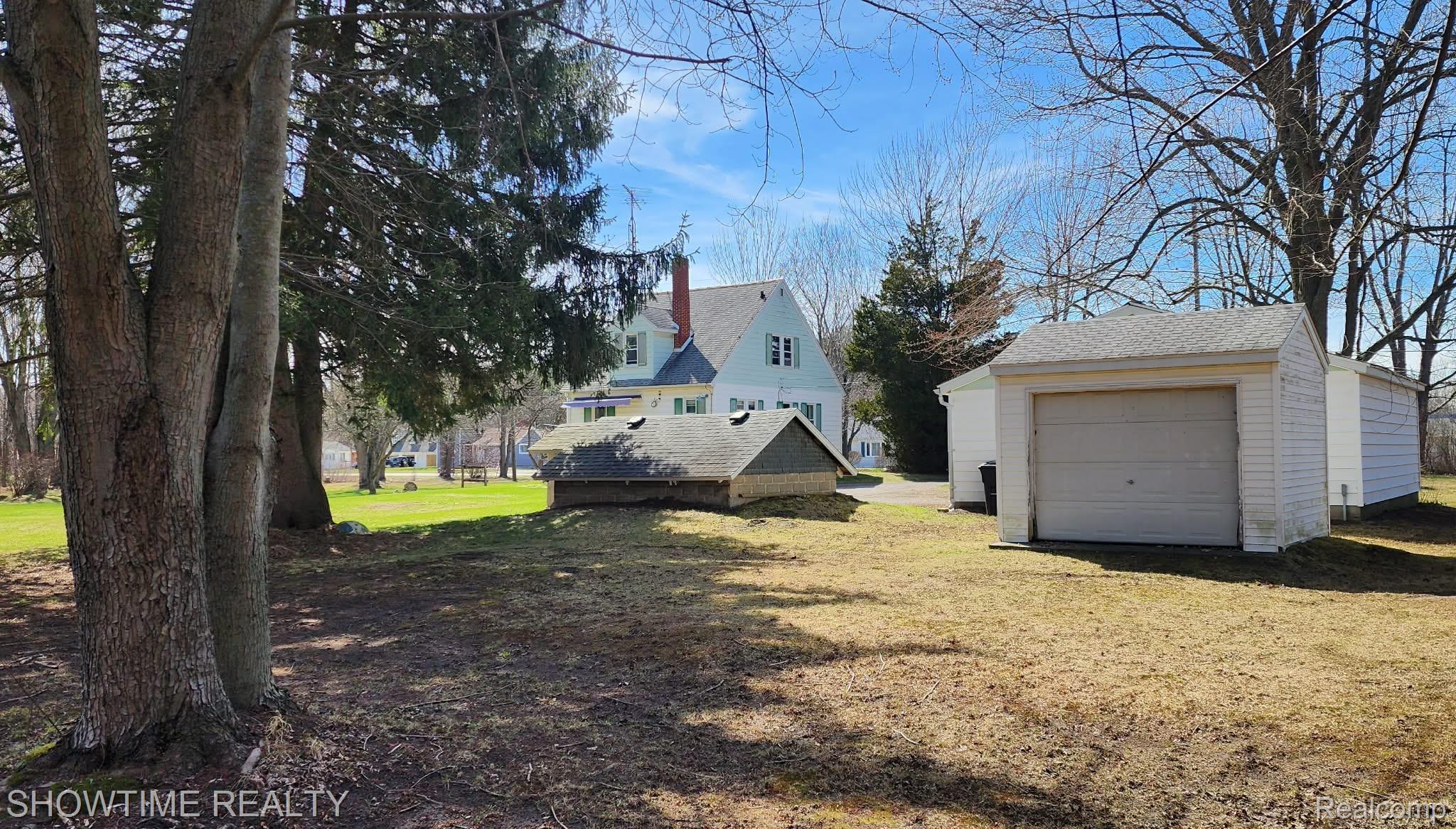 2970 Range Road Port Huron, MI 48060 - Photo 5 of 31 Expansive grounds featuring mature trees and a detached garage with an overhead door