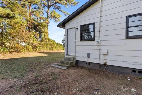 a view of backyard and wooden fence