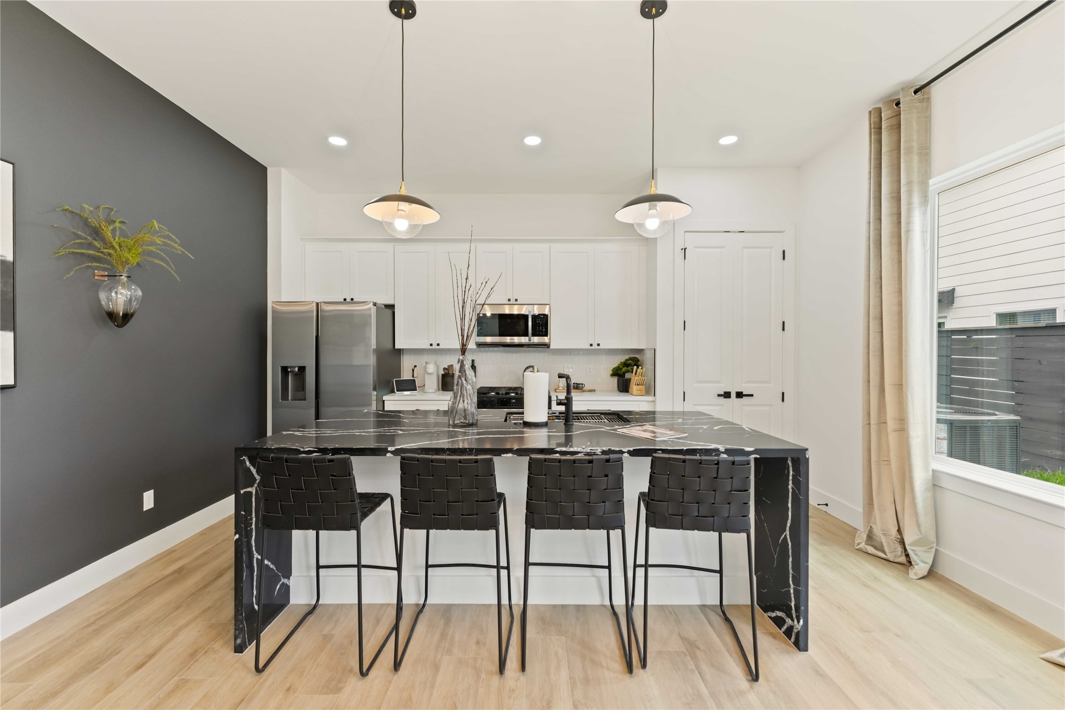 6539 Sealey Street Houston, TX 77091 - Photo 11 of 28 a kitchen with stainless steel appliances kitchen island granite countertop a dining table chairs and white cabinets