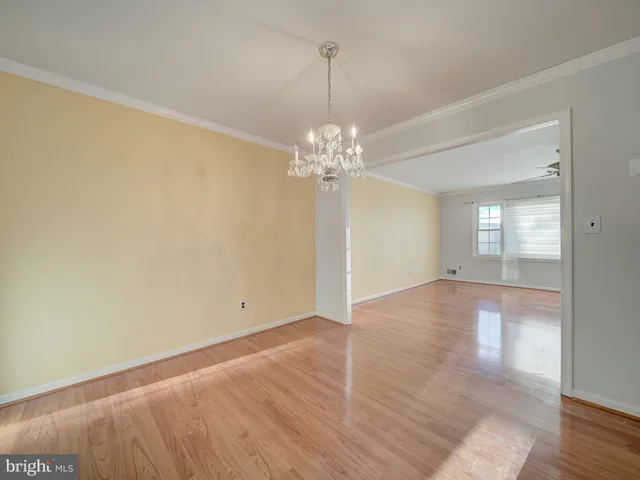 a view of a room with wooden floor and chandelier