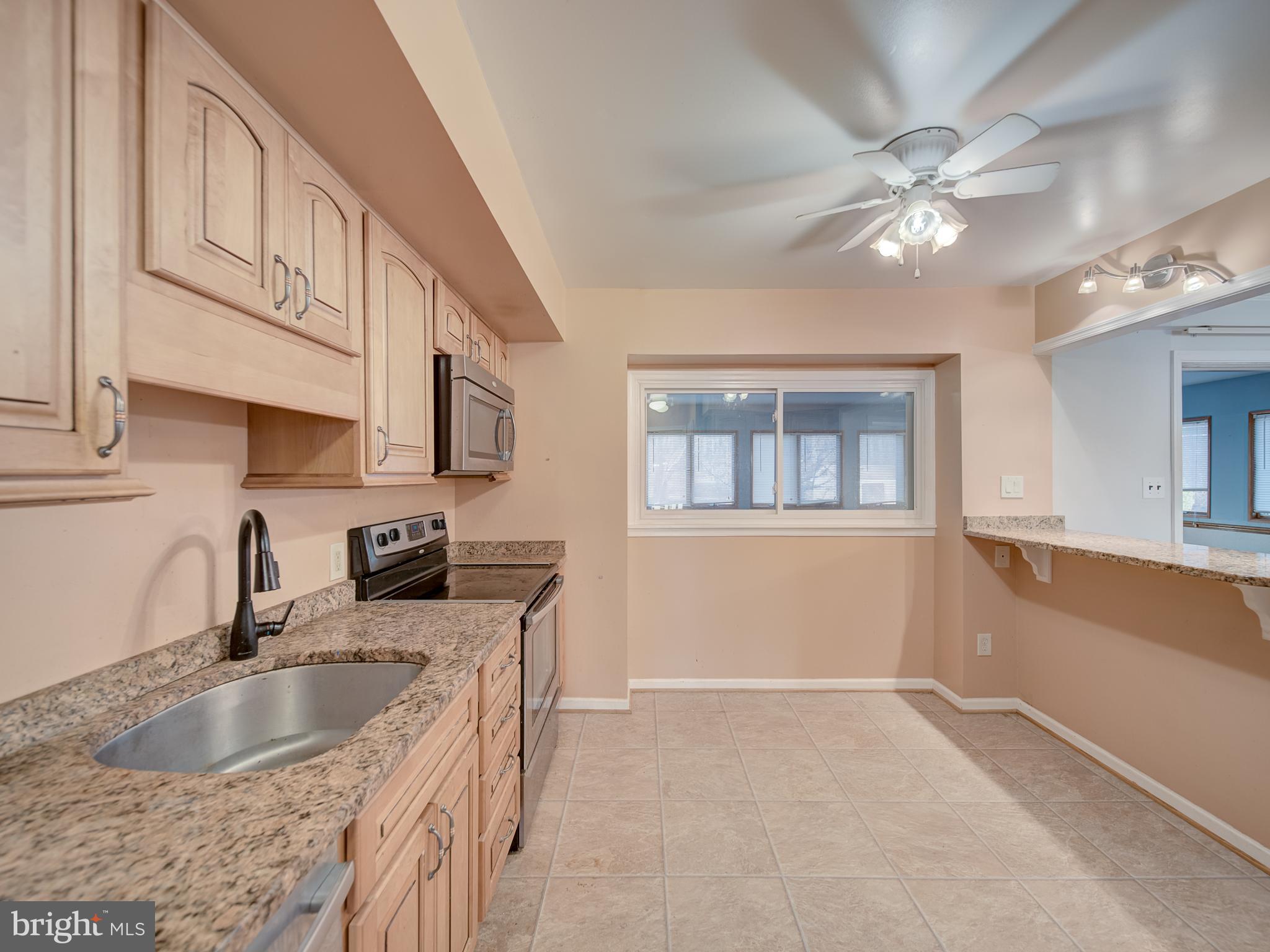 9315 Lees Ridge Road Warrenton, VA 20186 - Photo 22 of 51 a kitchen with stainless steel appliances granite countertop a sink a stove and a microwave oven