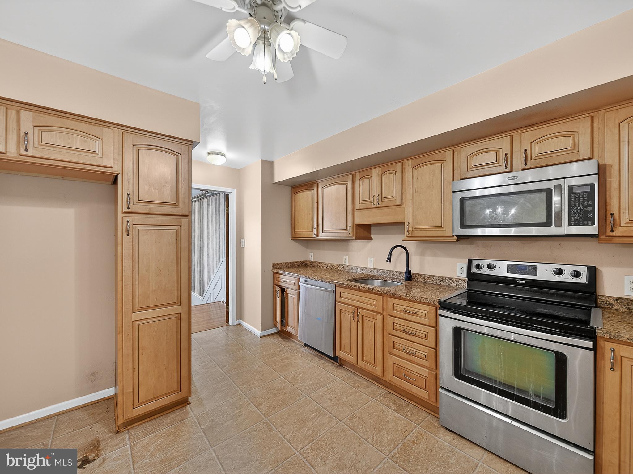 9315 Lees Ridge Road Warrenton, VA 20186 - Photo 27 of 51 a kitchen with stainless steel appliances granite countertop a refrigerator a stove a sink and a microwave