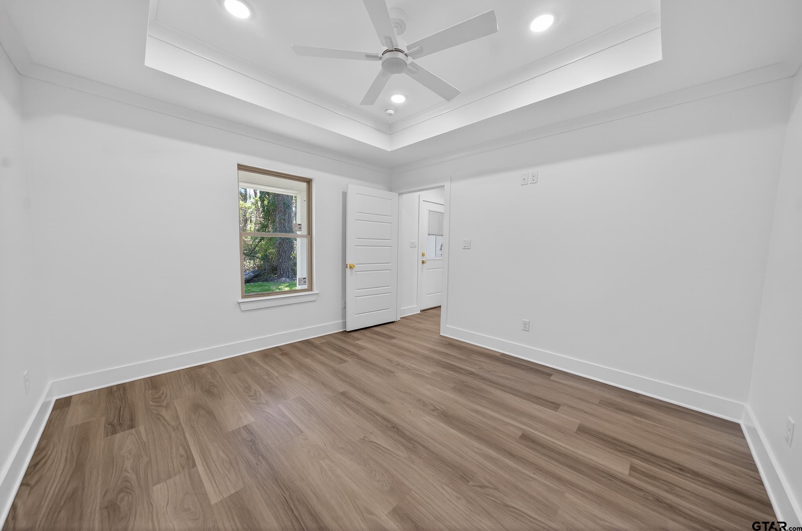 329 Wiley Drive Bullard, TX 75757 - Photo 20 of 31 an empty room with wooden floor chandelier fan and windows