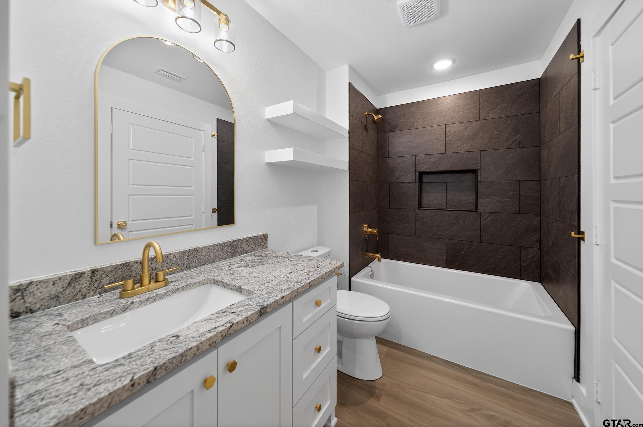 329 Wiley Drive Bullard, TX 75757 - Photo 22 of 31 a bathroom with a granite countertop sink a toilet and bathtub
