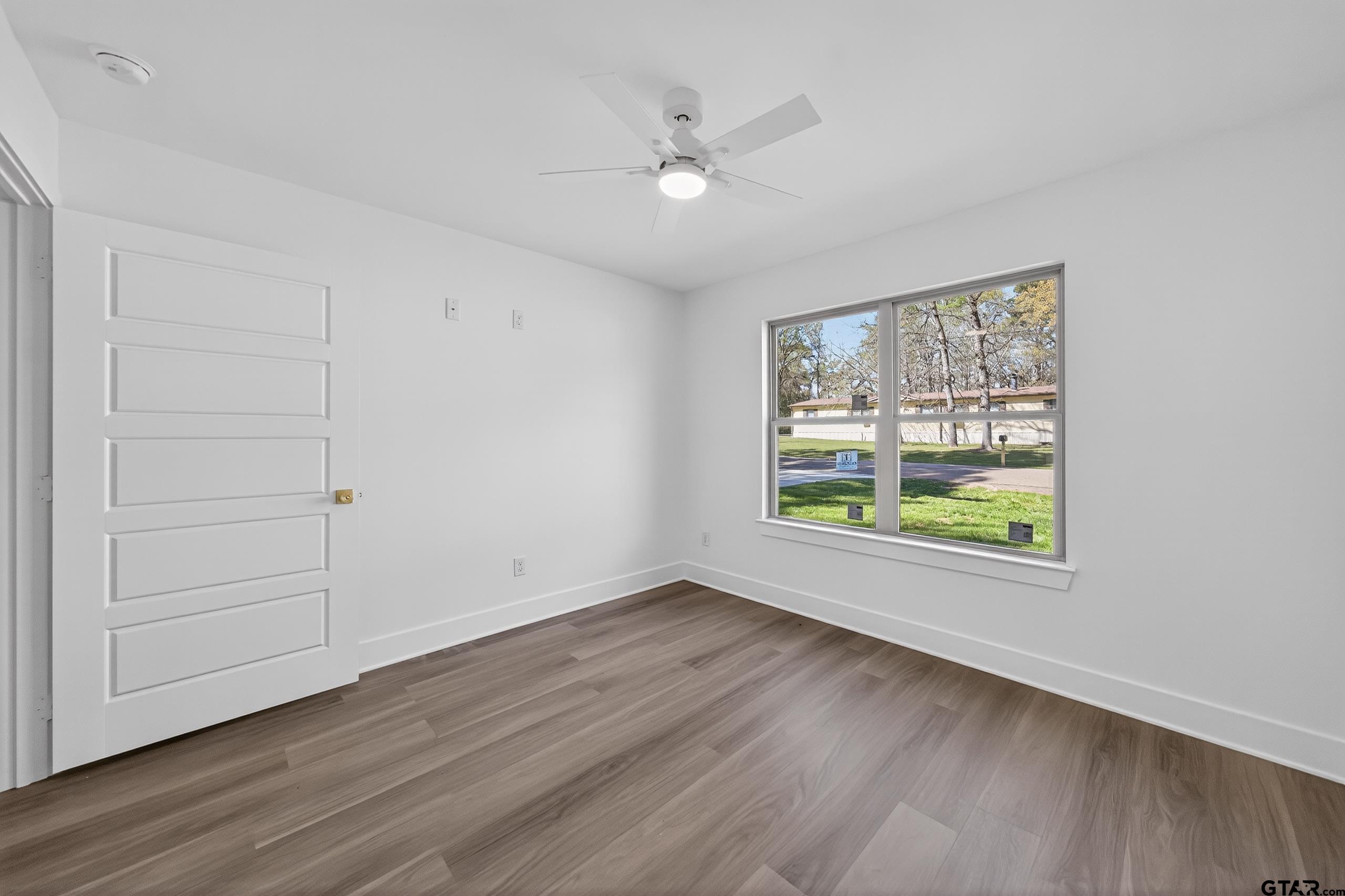 329 Wiley Drive Bullard, TX 75757 - Photo 31 of 31 an empty room with wooden floor chandelier fan and windows