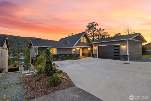 a front view of a house with a yard and potted plants