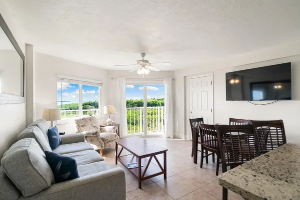 a living room with furniture a flat screen tv and a large window