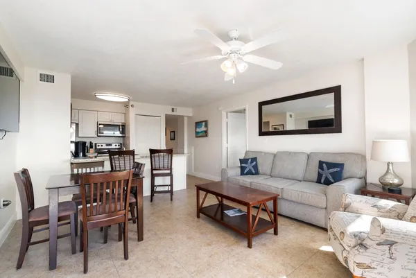 a living room with furniture and a view of kitchen