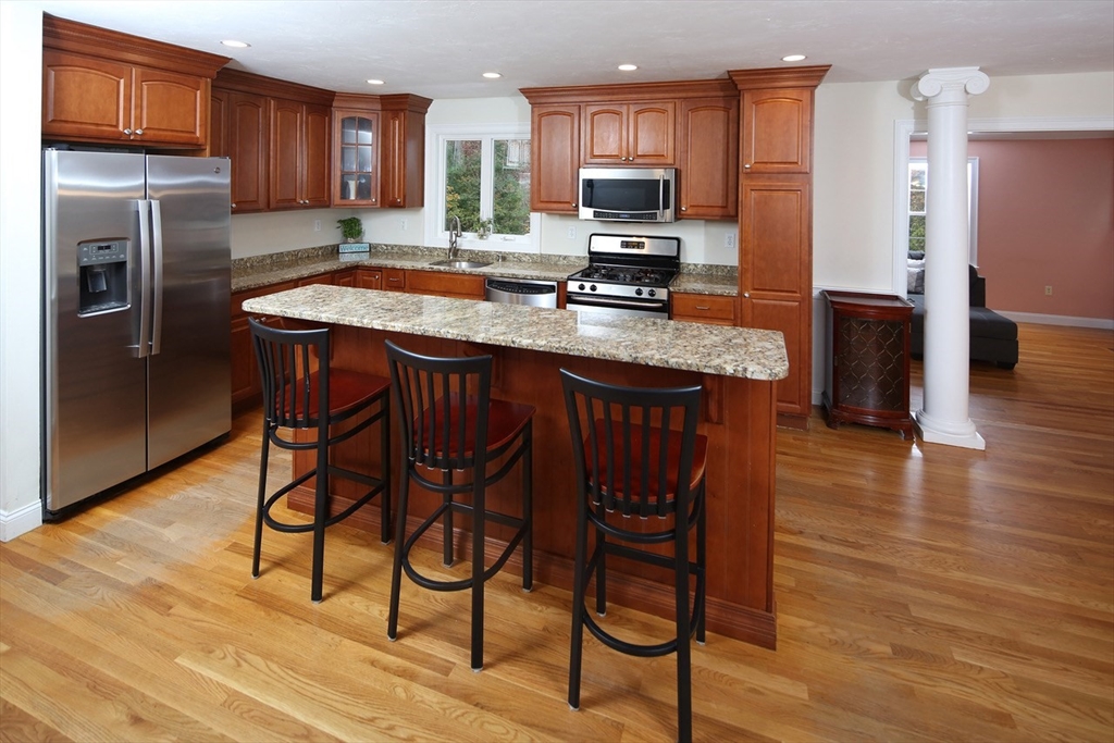 375 Webster Street Hanover, MA 02339 - Photo 5 of 24 a kitchen with stainless steel appliances granite countertop a table chairs sink refrigerator and microwave