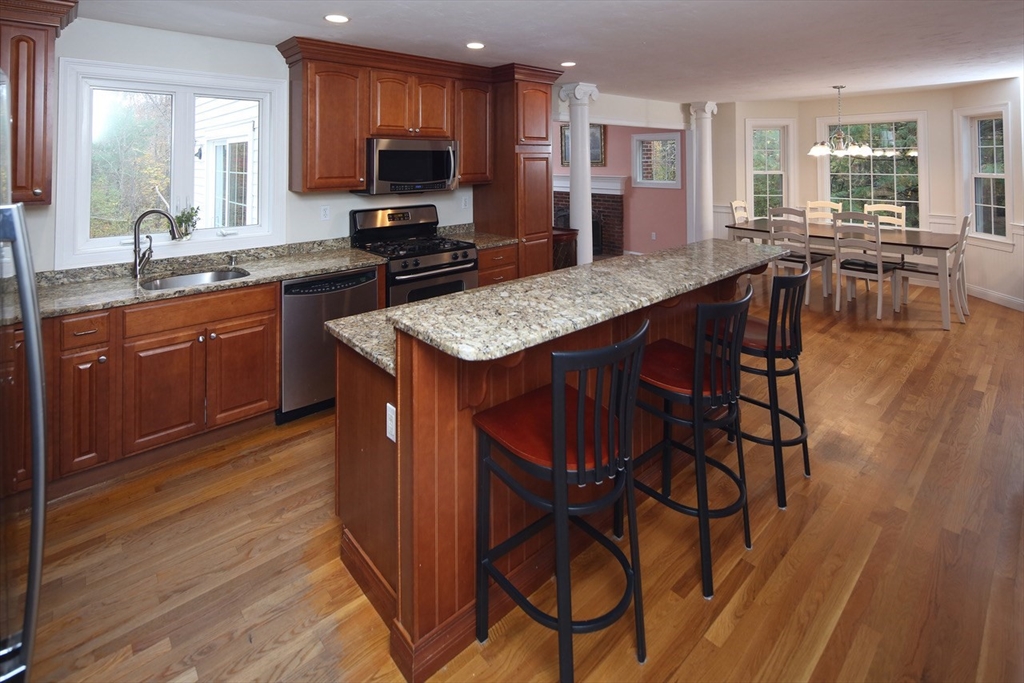 375 Webster Street Hanover, MA 02339 - Photo 6 of 24 a kitchen with stainless steel appliances granite countertop a table chairs sink refrigerator and cabinets