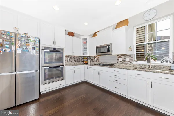 a large kitchen with granite countertop lots of counter space and a sink