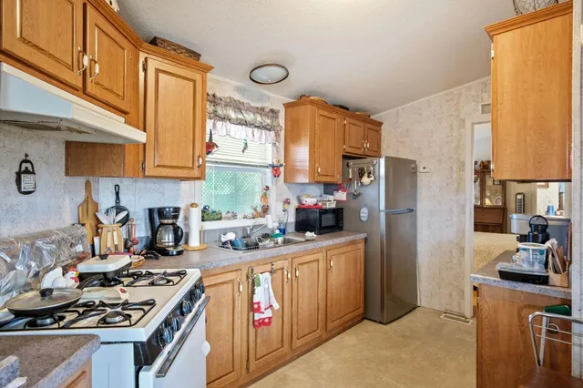 a kitchen with stainless steel appliances granite countertop a stove a sink and a white cabinets