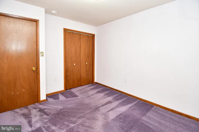 an empty room with windows and ceiling fan